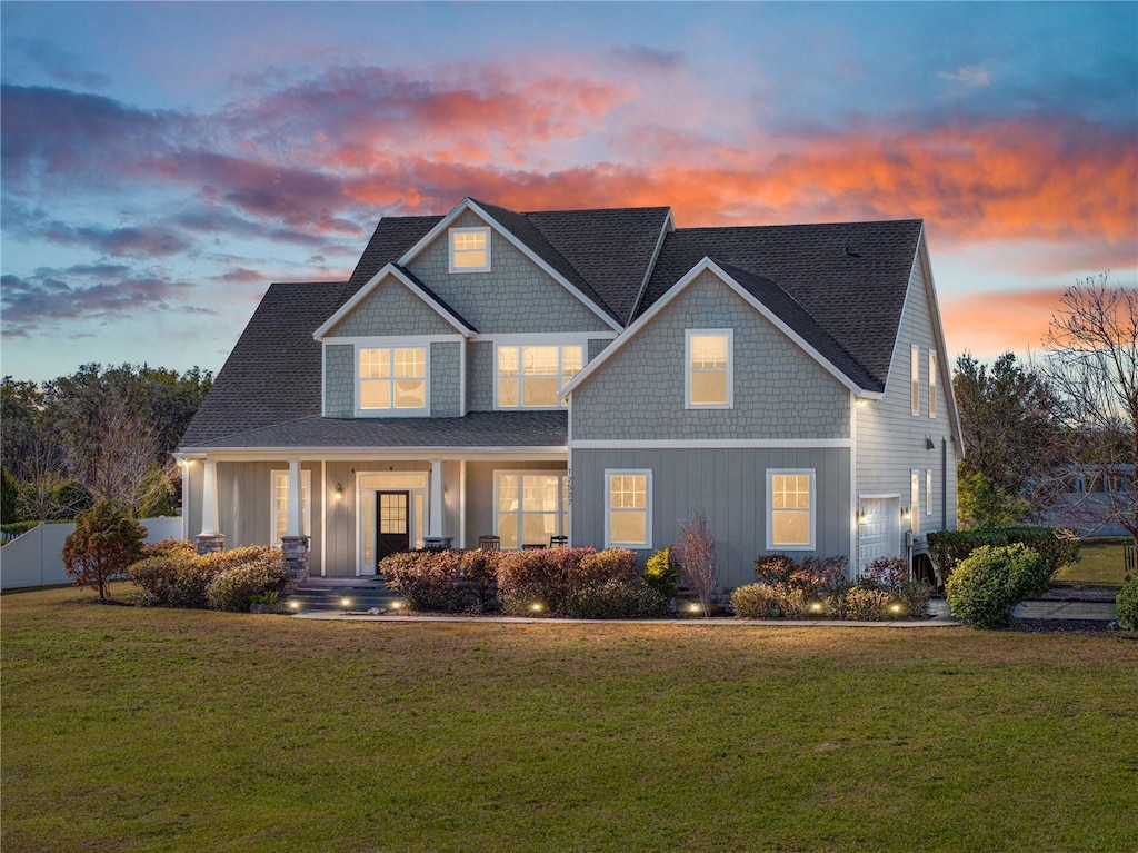 craftsman-style home featuring a lawn, a porch, and a garage