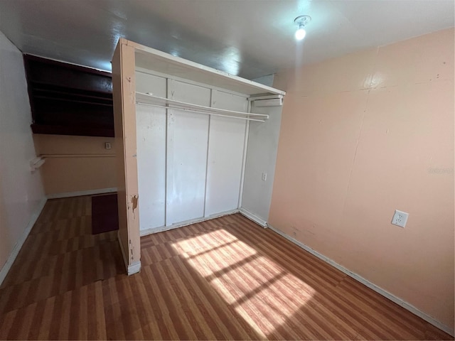 unfurnished bedroom featuring dark hardwood / wood-style floors and a closet