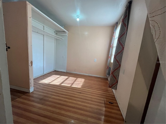 unfurnished bedroom featuring hardwood / wood-style floors and a closet