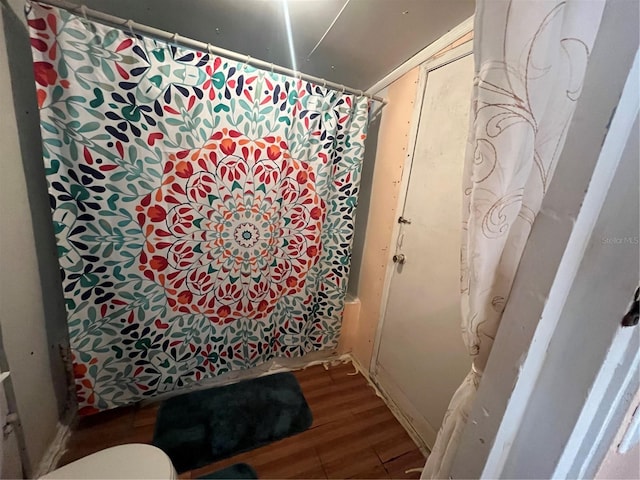 bathroom featuring wood-type flooring and shower / bath combo