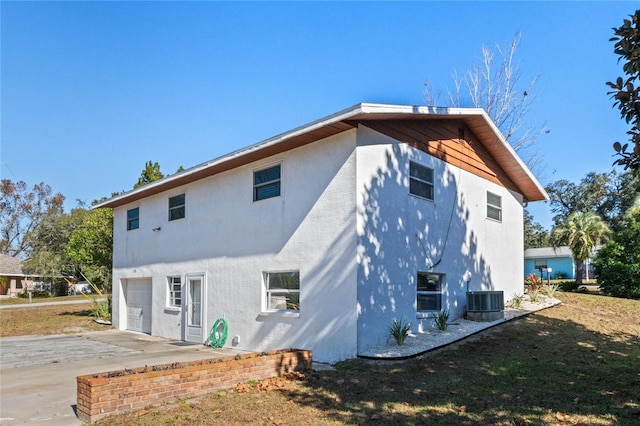 rear view of property featuring cooling unit and a garage