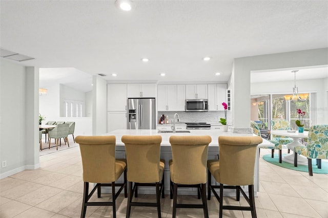 kitchen featuring white cabinets, sink, appliances with stainless steel finishes, tasteful backsplash, and kitchen peninsula