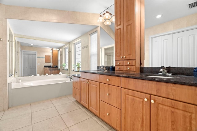 bathroom featuring tile patterned flooring, vanity, and a bath