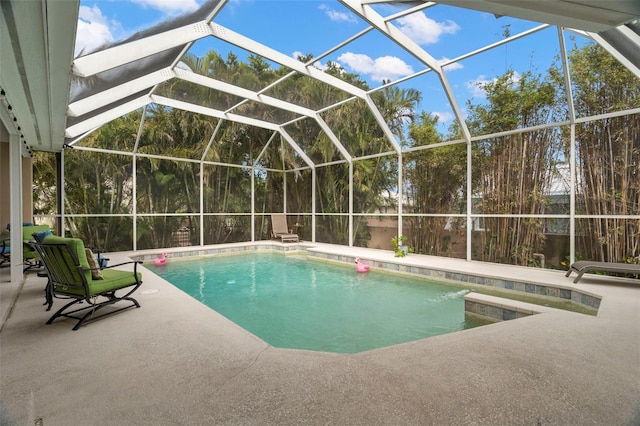 view of pool with a patio and glass enclosure