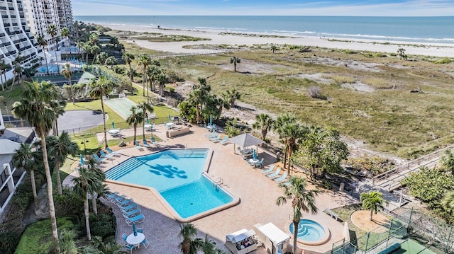 drone / aerial view with a water view and a beach view