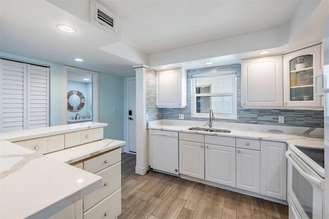 kitchen with white cabinetry, sink, light hardwood / wood-style floors, and white appliances