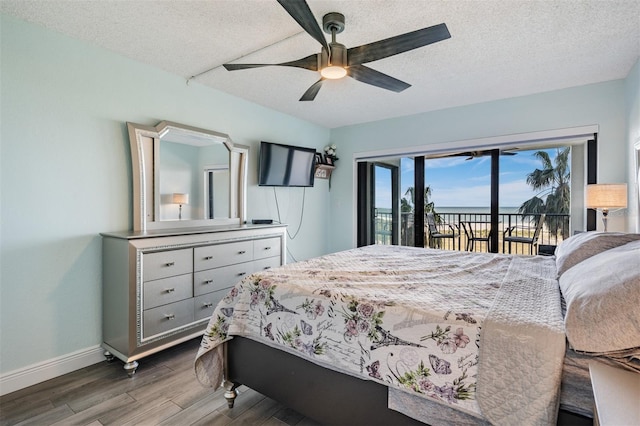 bedroom featuring hardwood / wood-style flooring, ceiling fan, access to exterior, and a textured ceiling