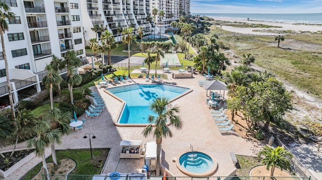 view of pool with a water view and a view of the beach