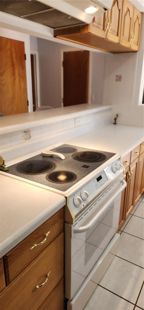 kitchen with light tile patterned floors and white electric range oven