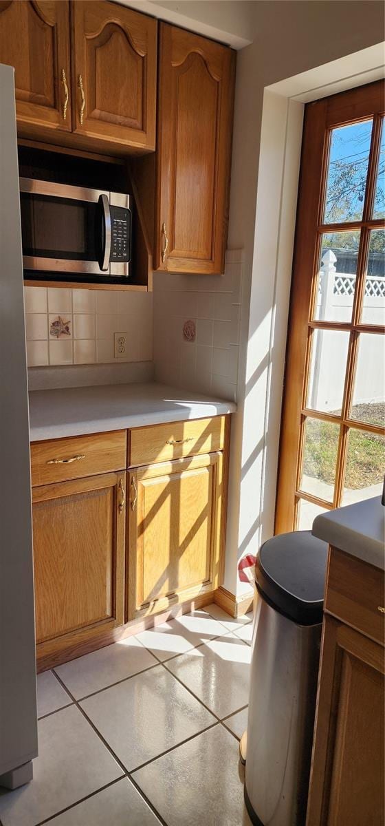 kitchen with decorative backsplash, light tile patterned flooring, and stainless steel appliances