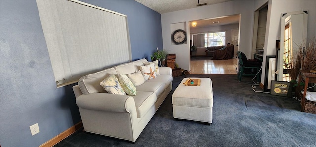 carpeted living room featuring a textured ceiling