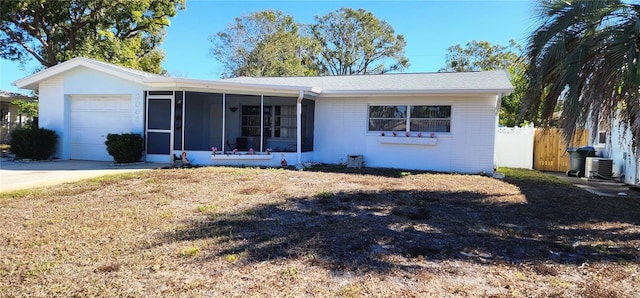 single story home featuring a garage, central AC unit, and a sunroom