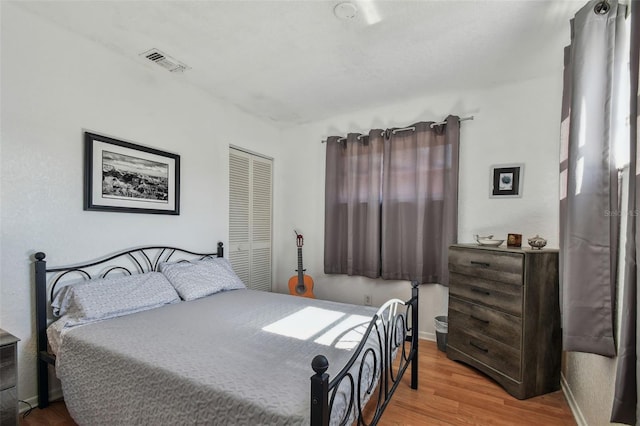 bedroom with wood-type flooring and a closet