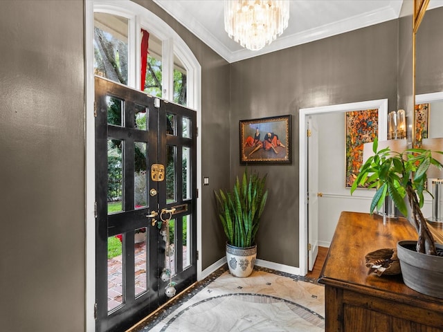 entryway with ornamental molding and an inviting chandelier