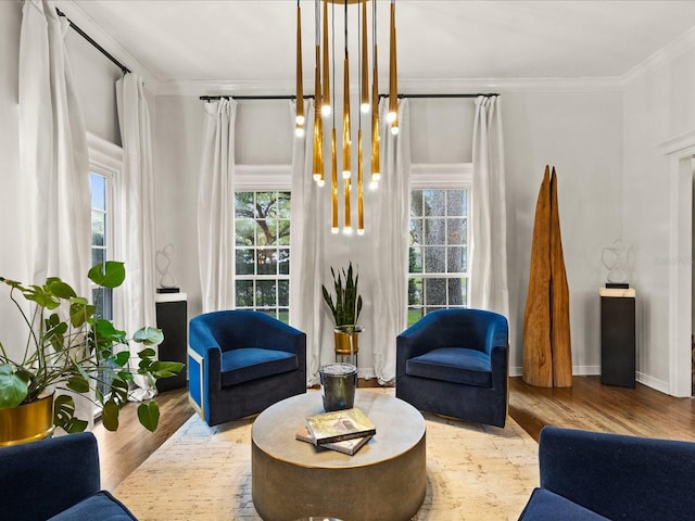 living area featuring light hardwood / wood-style flooring, a notable chandelier, and ornamental molding