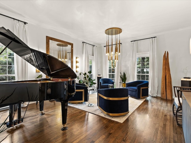 living area with crown molding, wood-type flooring, and a notable chandelier