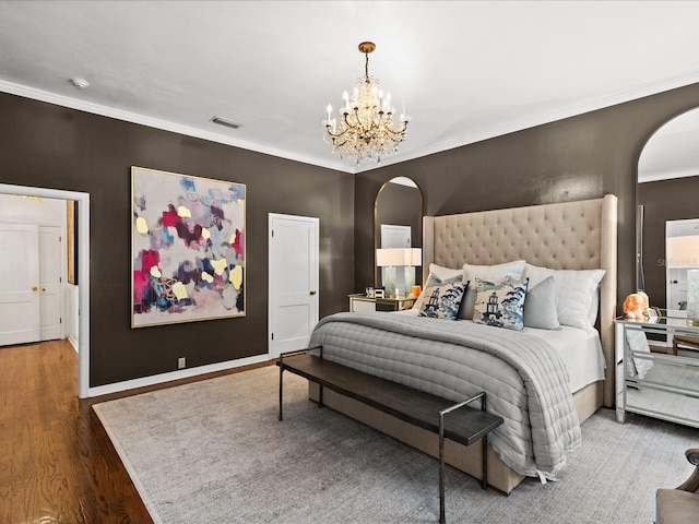 bedroom with wood-type flooring, ornamental molding, and a chandelier