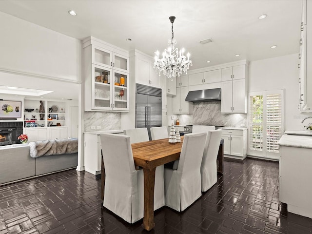 dining area with dark parquet floors, sink, and an inviting chandelier