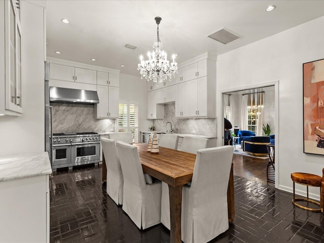 dining space with sink and an inviting chandelier