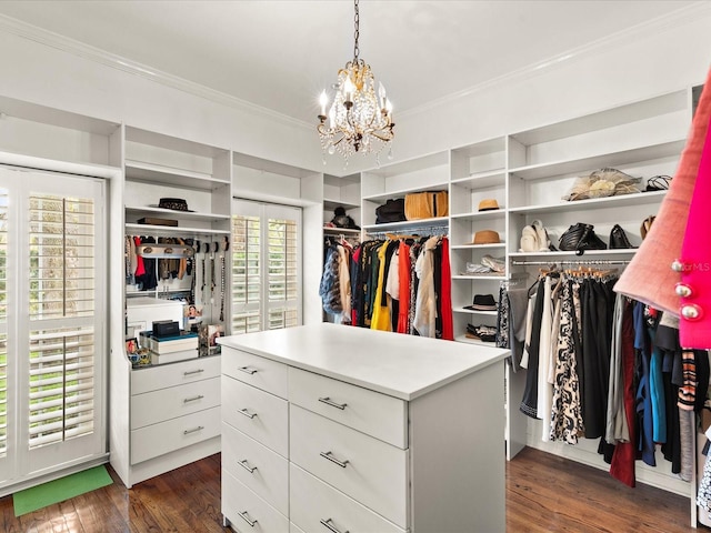 walk in closet featuring dark hardwood / wood-style flooring and an inviting chandelier