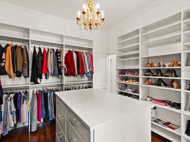 walk in closet featuring a chandelier and dark hardwood / wood-style flooring