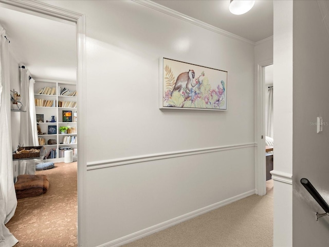 corridor with crown molding, built in features, and light carpet