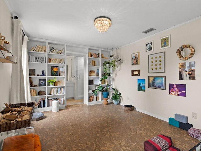 sitting room with built in shelves, crown molding, and a chandelier