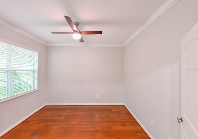 spare room featuring ceiling fan, dark wood-type flooring, and crown molding