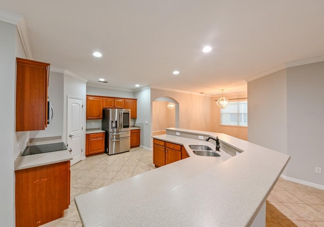 kitchen featuring sink, decorative light fixtures, an island with sink, crown molding, and appliances with stainless steel finishes