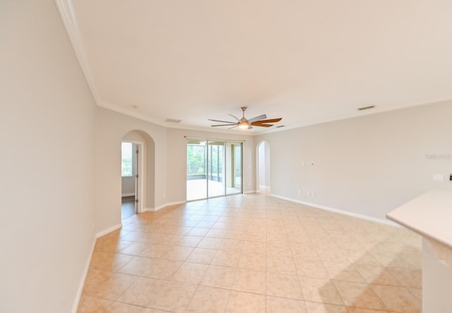 tiled spare room with ornamental molding and ceiling fan