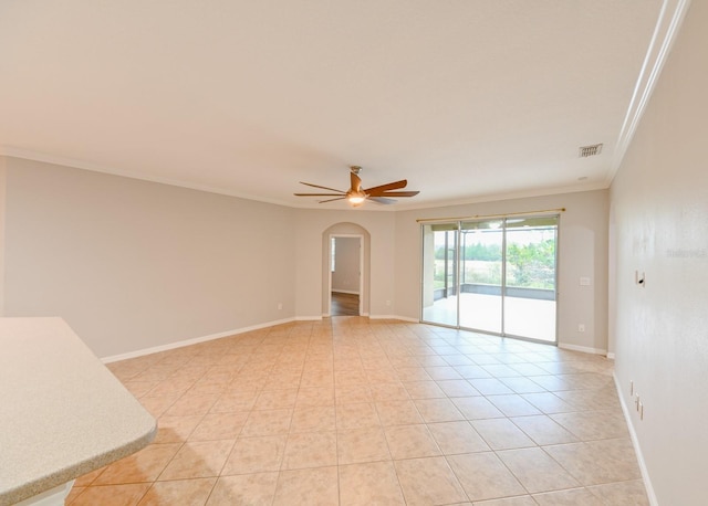 tiled spare room featuring ornamental molding and ceiling fan