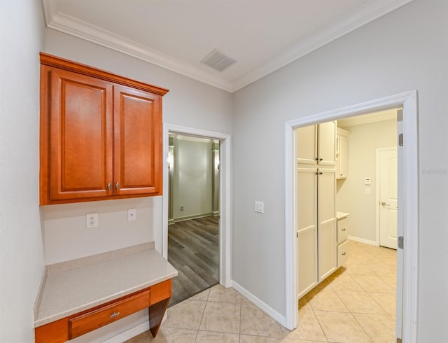 hall with ornamental molding and light tile patterned floors