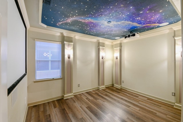 unfurnished room with wood-type flooring, a tray ceiling, and crown molding