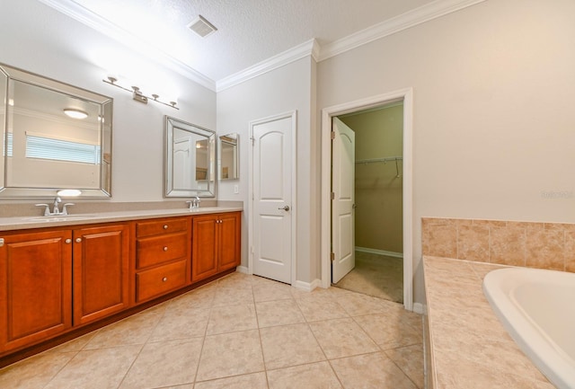 bathroom featuring vanity, tile patterned flooring, ornamental molding, and a bathtub