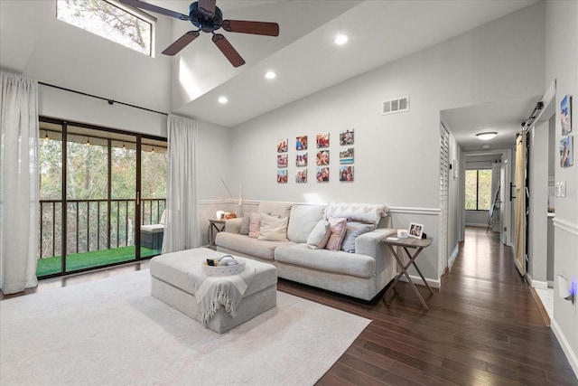 living room featuring ceiling fan, a barn door, dark hardwood / wood-style floors, and high vaulted ceiling