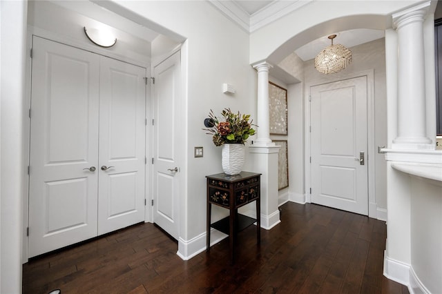 entrance foyer with dark hardwood / wood-style flooring, ornamental molding, and decorative columns