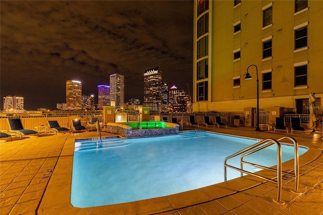 view of swimming pool with a patio area and a hot tub