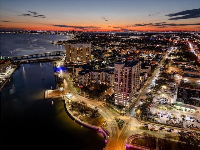 aerial view at dusk featuring a water view