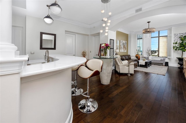 bathroom with sink, wood-type flooring, ornamental molding, and a notable chandelier