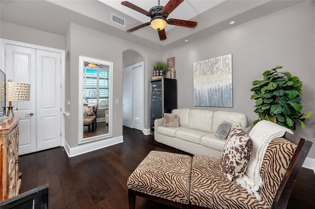 living room featuring ceiling fan and dark hardwood / wood-style floors