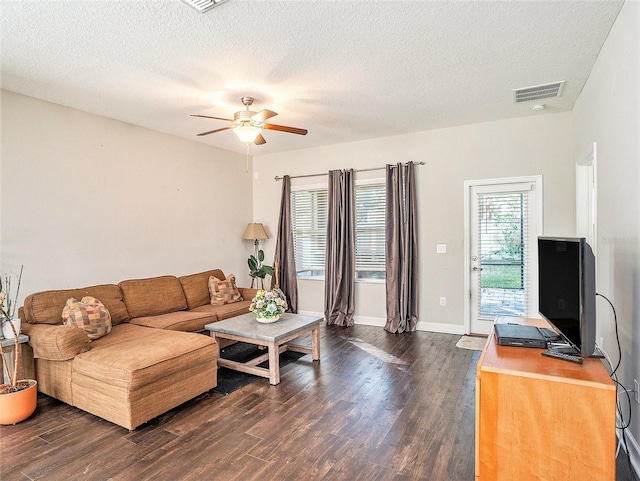 living room with ceiling fan, dark hardwood / wood-style floors, and a textured ceiling