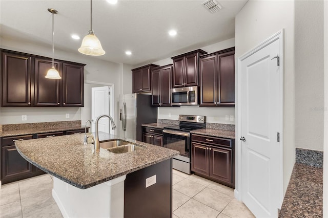 kitchen with appliances with stainless steel finishes, sink, a kitchen breakfast bar, hanging light fixtures, and a kitchen island with sink