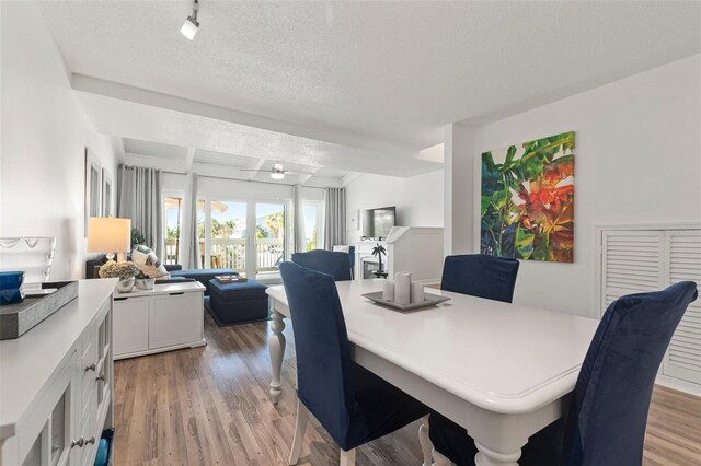 dining space with light hardwood / wood-style floors and a textured ceiling