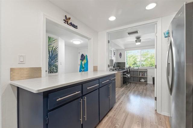 kitchen with ceiling fan, light hardwood / wood-style floors, blue cabinetry, and stainless steel refrigerator