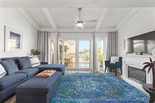 living room with hardwood / wood-style floors, ceiling fan, beam ceiling, and wooden ceiling