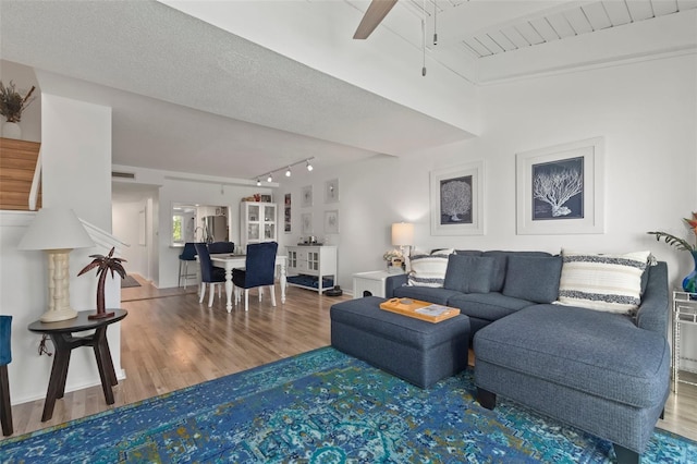 living room featuring a textured ceiling, ceiling fan, hardwood / wood-style floors, and track lighting