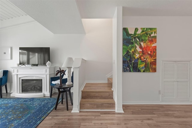 stairs featuring hardwood / wood-style flooring and lofted ceiling