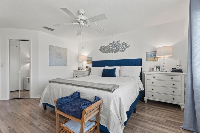 bedroom featuring hardwood / wood-style flooring, ceiling fan, and a closet