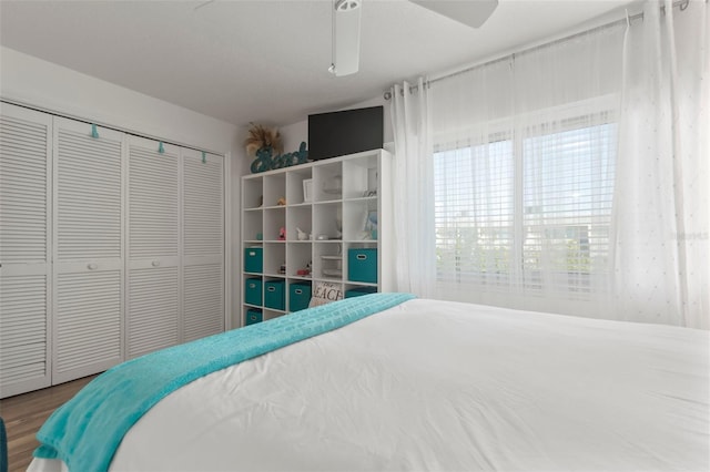 bedroom with a closet, ceiling fan, and hardwood / wood-style flooring