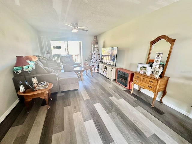 living room with hardwood / wood-style floors, ceiling fan, and a textured ceiling